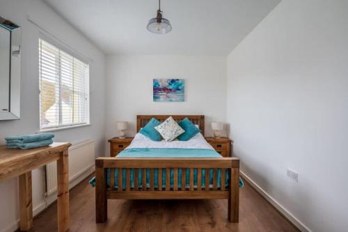 a bedroom with a bed and a window at 55 Incline Way - Saundersfoot Coastal Retreat with Patio & Parking in Pembrokeshire