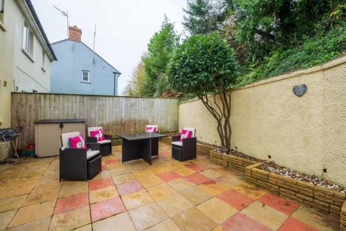 a patio with chairs and a table and a fence at 55 Incline Way - Saundersfoot Coastal Retreat with Patio & Parking in Pembrokeshire
