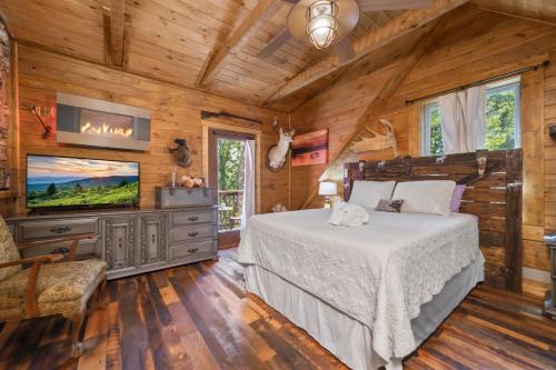 a bedroom with a bed and a flat screen tv at Tranquility Cove Lodge in Dandridge