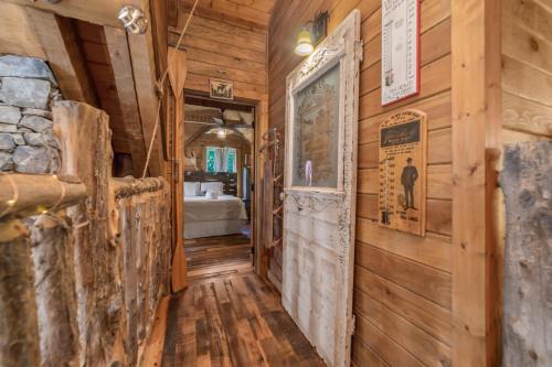 a hallway in a cabin with wooden walls and a bedroom at Tranquility Cove Lodge in Dandridge
