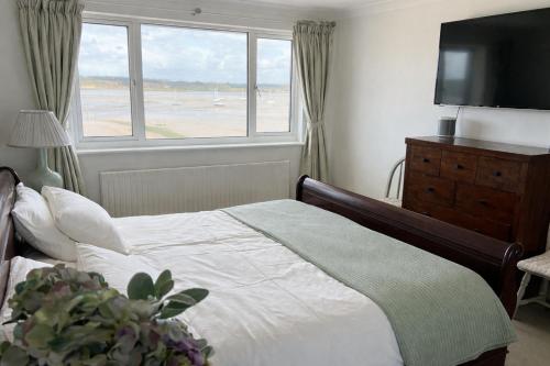 a bedroom with a bed and a large window at Beach House Manningtree in Manningtree