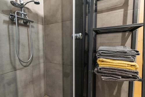 a stack of towels on a towel rack in a shower at Vilka Cibulka a chata Cesnačik in Ižipovce