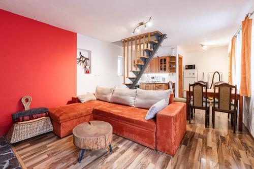 a living room with a couch and a red wall at Vilka Cibulka a chata Cesnačik in Ižipovce