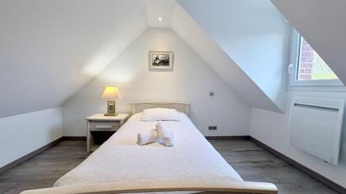a attic bedroom with two beds and a window at Le Nid Des Grands Geais in Le Crotoy