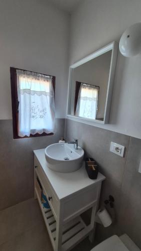 a bathroom with a white sink and a mirror at La Perla del Boccaccio in Certaldo