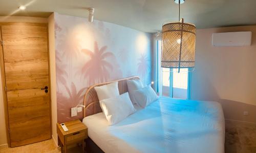 a bedroom with a bed with a palm tree mural at La Maison Cavet 6 Appartements de standing au cœur du village in Sanary-sur-Mer
