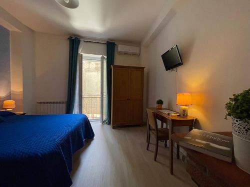 a bedroom with a bed and a desk and a television at Al Palmento in Galati Mamertino