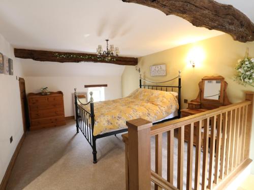 a bedroom with a bed and a wooden staircase at Orchard View in Alfreton