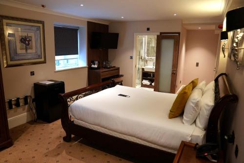 a bedroom with a large white bed in a room at The Tudor Hotel in Harrow