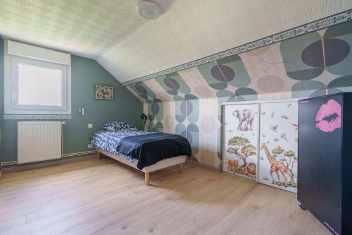 a bedroom with a bed with a mural on the wall at La Clairière de Dogneville - proche Epinal in Dogneville