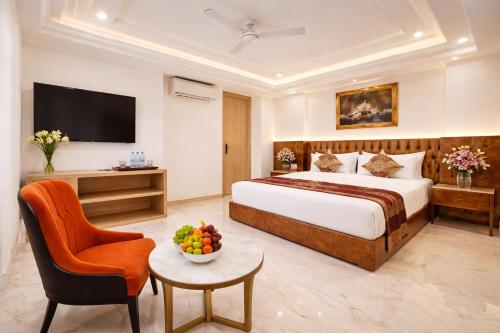 a hotel room with a bed and a chair at Rahitya Premier in New Delhi