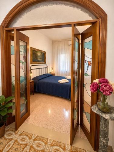 a bedroom with a bed and a glass doorway at ADAapartmenthousesalerno in Salerno