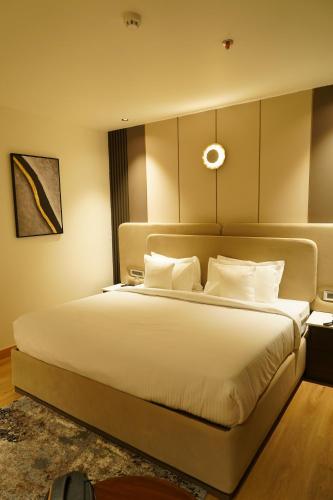 a bedroom with a large bed with white pillows at Hotel Luxe Manor in Mohali