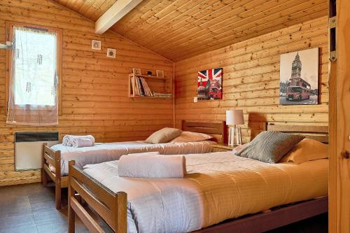 a bedroom with two beds in a log cabin at Chalet Solariale in La Teste-de-Buch