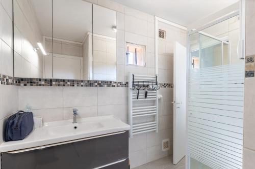 a white bathroom with a sink and a shower at Le cocon de Boutiny - à Peymeinade in Peymeinade
