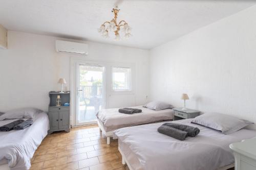 a bedroom with two beds and a chandelier at Le cocon de Boutiny - à Peymeinade in Peymeinade