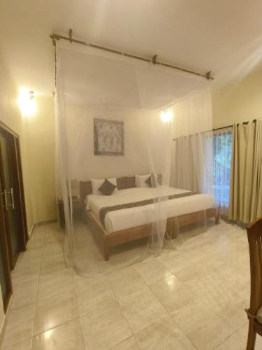 a bedroom with a bed with a canopy at Puri Sari Beach Hotel in Labuan Bajo
