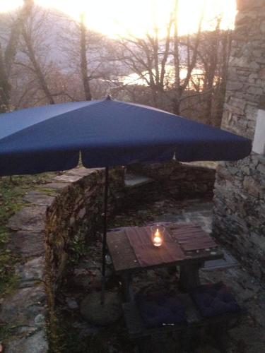 a blue umbrella over a picnic table with a candle at Helle Sonne in Agarone