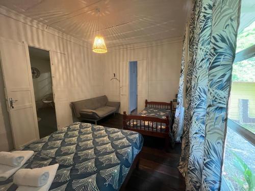 a bedroom with a bed and a couch and a chair at La Kaz Yab in Salazie