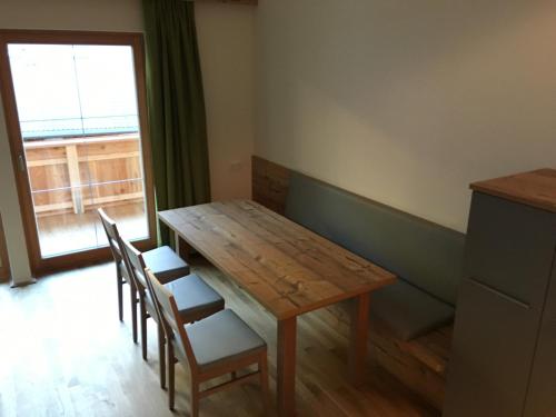 a wooden table and chairs in a room with a window at Ferienwohnung Neubau in Alpbach