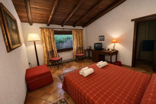 ein Schlafzimmer mit einem roten Bett, einem Tisch und Stühlen in der Unterkunft Crapa Licca in Ventimiglia di Sicilia