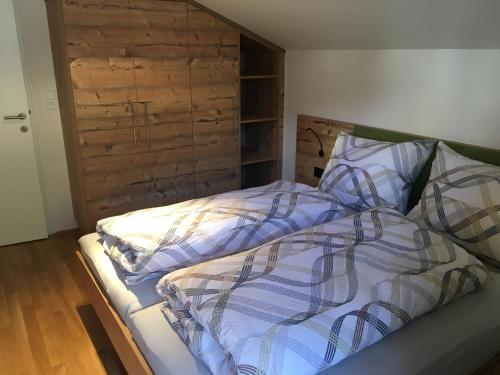 a bedroom with a bed with a wooden headboard at Ferienwohnung Neubau in Alpbach