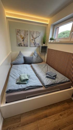 a bed with two pillows on it in a room at Fewo Wellenklang Hainer See bei Leipzig in Neukieritzsch