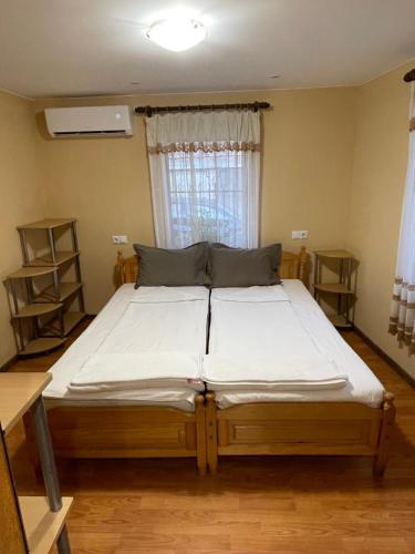 a large bed in a room with a window at Къщи "И пак дойдох" in Tryavna