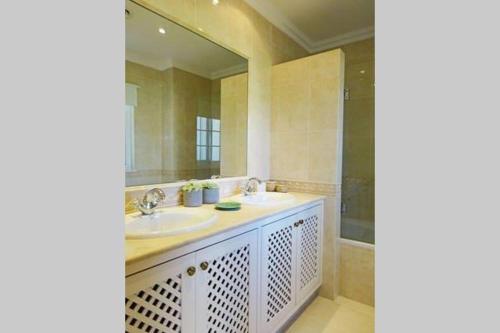 łazienka z 2 umywalkami i dużym lustrem w obiekcie Formosa Villas w mieście Quinta do Lago