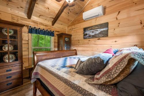 a bedroom with a bed in a log cabin at Smoky Mountain Mist, Tiny House, Custom Log Cabin in Bryson City