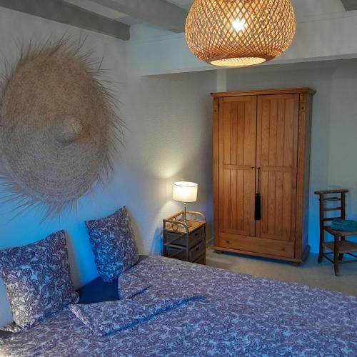 a bedroom with a bed and a wooden cabinet at gite que canta in Saint-Julien-Vocance