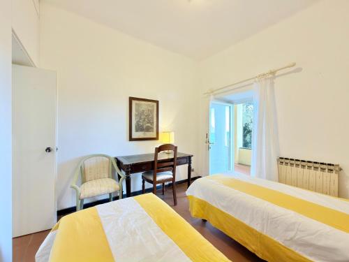 a bedroom with two beds and a desk and a table at VILLA TRAMONTO in Levanto