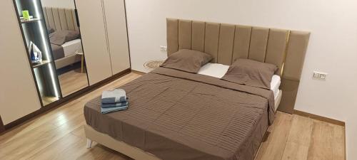 a large bed in a room with a mirror at Villa AM in Awlād ‘Umar