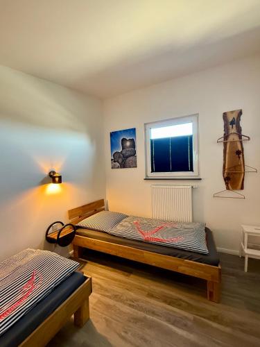 a bedroom with two beds and a window at Inselbutze Fehmarn in Fehmarn