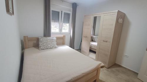 a small bedroom with a bed and a dresser at Sweet Hilltop Escape in Zelenika