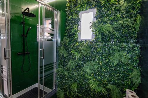 a bathroom with a green wall covered in plants at Villa Salvaje Beach in San Francesch