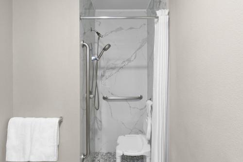 a shower with a glass door in a bathroom at Super 8 by Wyndham Chattanooga East - Hamilton Place in Chattanooga