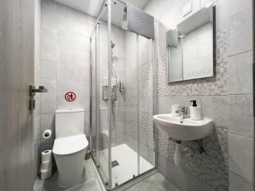 a bathroom with a shower and a toilet and a sink at Albert's apartment Center 101 in Larnaca
