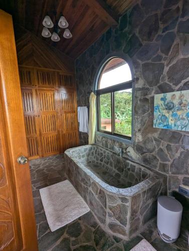 a large stone tub in a room with a window at Villa Siempre Aventura in Nuevo Arenal