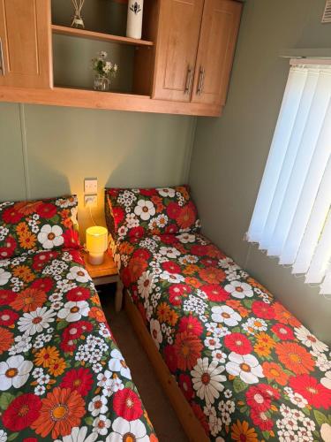 two beds sitting next to each other in a room at Browns caravan rentals, ingoldmells 4 berth caravan silver beach in Ingoldmells