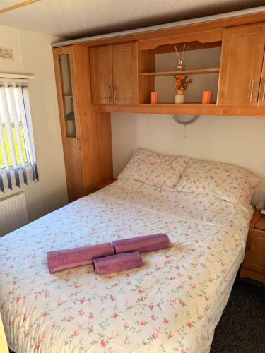 a bedroom with a bed with wooden cabinets at Browns caravan rentals, ingoldmells 4 berth caravan silver beach in Ingoldmells