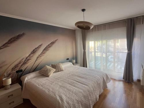 a bedroom with a bed and a large window at Pegadas no mar in Ribeira