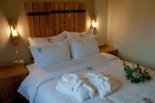 a bed with white sheets and towels on it at 4 Seasons in Vizitsa in Vizitsa