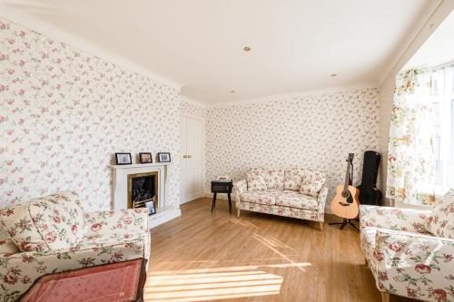 a living room with a couch and a guitar at George Harrison's Former 3Bed Home in Liverpool in Speke