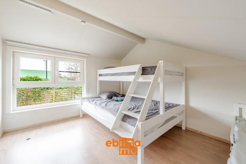 a bedroom with a bunk bed and a window at Zee en Polder 134 in Middelkerke