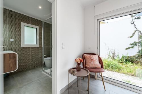 a bathroom with a chair and a window at Villa Adão Lobo in Cadaval