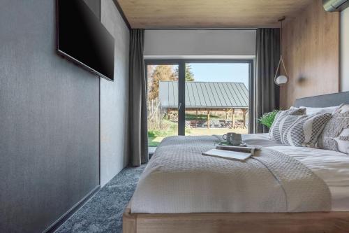 a bedroom with a bed with a television on the wall at Wierchy View - bespoke villas in Kościelisko