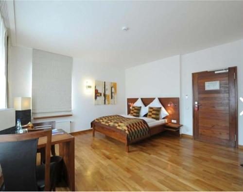 a bedroom with a bed and a table and a desk at Hotel Nassauer Hof in Kiedrich