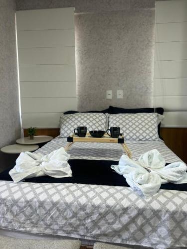 a bed with two bowls on top of it at Loft sua morada in Capão da Canoa