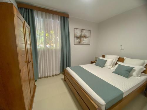 a bedroom with a large bed and a window at Hasoa Villa in Morondava